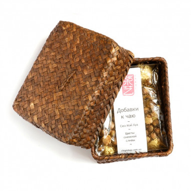 Порційний білий чай з квітами снігу сливи в плетеному кошику.